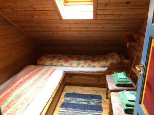 two beds in a wooden cabin with a window at Naustloftet in Hornindal