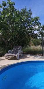 a lounge chair sitting next to a swimming pool at Chillout Apartments with Pool Patricia in Fažana
