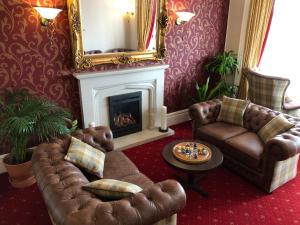 a living room with a couch and a fireplace at Queenswood Hotel in Weston-super-Mare