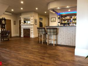 a bar with chairs and a fireplace in a room at Queenswood Hotel in Weston-super-Mare
