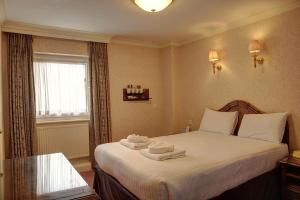 a hotel room with a bed with towels on it at The Orwell Hotel in Felixstowe