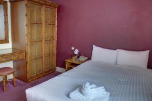 a bedroom with a bed with towels on it at The Orwell Hotel in Felixstowe