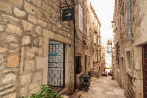 an alley with a door in an old building at Puntin Rooms apartman in Korčula