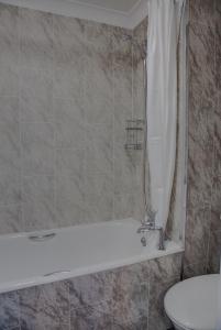 a bathroom with a shower and a tub and a toilet at The Orwell Hotel in Felixstowe