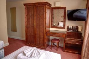 a bedroom with a desk and a dresser with a mirror at The Orwell Hotel in Felixstowe