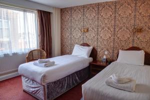 a hotel room with two beds and a window at The Orwell Hotel in Felixstowe