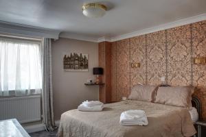 a bedroom with a bed with two towels on it at The Orwell Hotel in Felixstowe