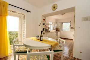 a kitchen and dining room with a table and chairs at Puntin Rooms apartman in Korčula
