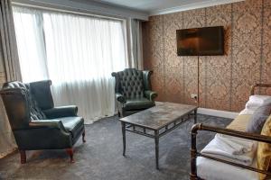 a room with two chairs and a table and a tv at The Orwell Hotel in Felixstowe