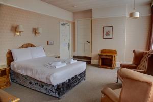 a hotel room with a bed and a chair at The Orwell Hotel in Felixstowe