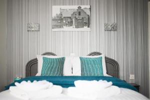 a bedroom with a bed with blue and white pillows at The Orwell Hotel in Felixstowe