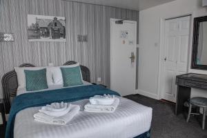 a bedroom with a bed with towels on it at The Orwell Hotel in Felixstowe