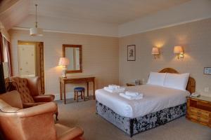 a hotel room with a bed and a chair at The Orwell Hotel in Felixstowe