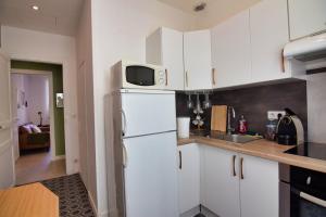 een keuken met witte kasten en een witte koelkast bij Atlantico - Arrosa in Biarritz