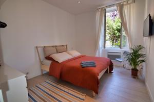 een slaapkamer met een bed met een rode deken en een raam bij Atlantico - Arrosa in Biarritz