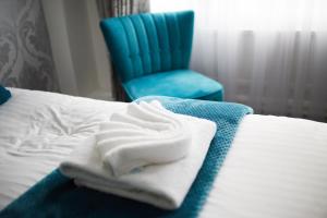 a hotel room with a bed and a blue chair at The Orwell Hotel in Felixstowe
