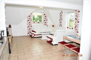 a living room with white furniture and red curtains at Fewo Traum in Neppermin