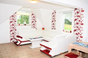 a living room with white furniture and red accents at Fewo Traum in Neppermin
