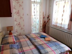 a bedroom with a bed with a plaid blanket at Apartman Nena in Nova Varoš