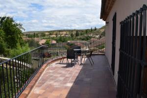 einen Balkon mit zwei Stühlen und einem Tisch darauf in der Unterkunft La Canaleja in Torre Val de San Pedro