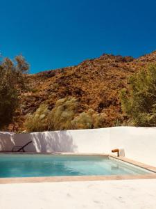 an empty swimming pool with a mountain in the background at Mill.Space in Carboneras