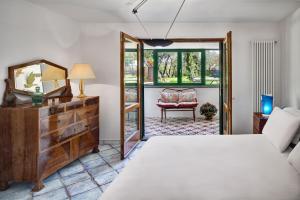 a bedroom with a bed and a mirror and a chair at Stony Villa Volcano View in SantʼAgata sui Due Golfi +28 photos