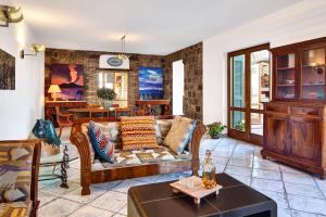 a living room with a couch and a table at Stony Villa Volcano View in SantʼAgata sui Due Golfi