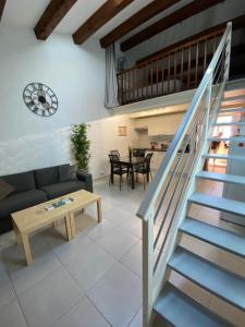 een woonkamer met een trap en een tafel bij Appartement Les grands pins in Les Issambres