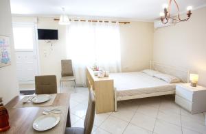 a bedroom with a bed and a dining table at Ammos Studios & Apartments in Nea Peramos