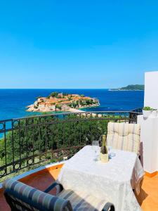 a table with a bottle of wine sitting on a balcony at Villa Milan in Sveti Stefan