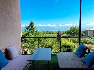 een balkon met 2 bedden, een tafel en uitzicht bij Villa Tsinandali in Tsinandali