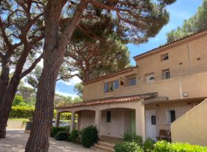 een groot gebouw met bomen ervoor bij Appartement Les grands pins in Les Issambres