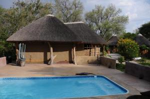 a small hut with a swimming pool in front of it at Discovery Bed and Breakfast in Maun