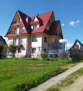 dom z czerwonym dachem na szczycie pola w obiekcie U Marii & Mariana w Leśnicy
