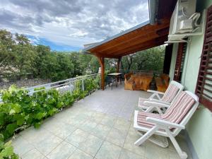 a patio with two chairs and a table on a balcony at Apartman Mira in Karlobag