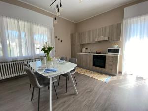 a dining room with a white table and chairs at Appartamento Renzo, Dongo, Lago di Como in Dongo +21 photos