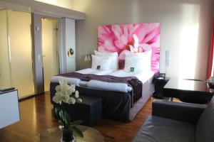 una habitación de hotel con una cama grande con una flor rosa en la pared en Clarion Hotel Bergen Airport en Bergen