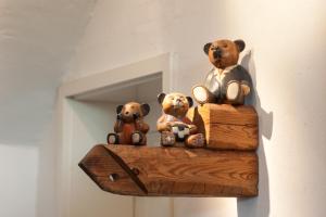 three teddy bears sitting on top of a piece of wood at Gästehaus BärenHof in Barkhagen