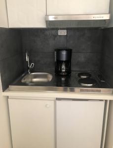 a kitchen with a sink and a coffee maker on a counter at "Aux Balcons du Riou" avec vue mer 180 degrés in Vence