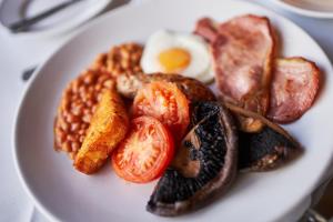a plate of breakfast food with an egg and beans at The Orwell Hotel in Felixstowe