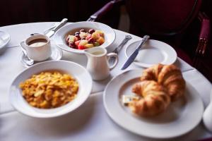 a table with plates of food and cups of coffee and croissants at The Orwell Hotel in Felixstowe