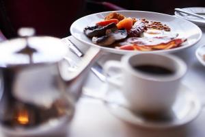 a plate of food and a cup of coffee on a table at The Orwell Hotel in Felixstowe