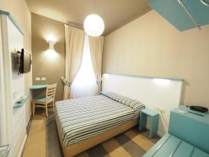 a small bedroom with a bed and a window at Hotel La Spiaggia in Monterosso al Mare