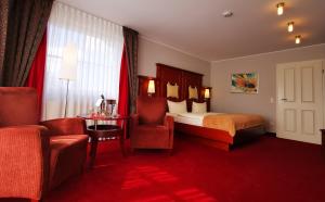 ein Hotelzimmer mit einem Bett und einem Stuhl in der Unterkunft Hotel Garni Bendiks in Horumersiel