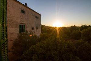 an old building with the sunset in the background at Agroturismo Son Sant Andreu in Petra