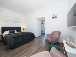 een slaapkamer met een bed en een stoel bij Arena Delight Studio Apartments in Pula