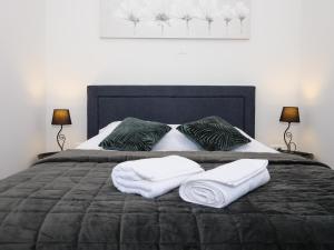 łóżko z dwoma ręcznikami i dwoma lampami w obiekcie Arena Delight Studio Apartments w Puli