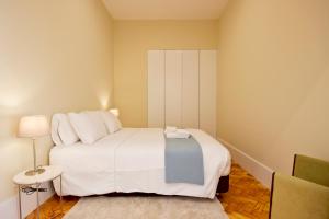 1 dormitorio con 1 cama blanca grande y 1 silla en Ribeira - Dixos Oporto Apartments IV, en Oporto