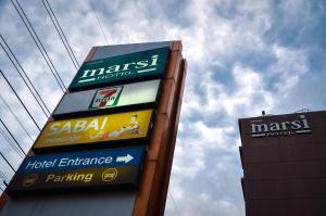 a sign for a gas station next to a building at Marsi Hotel Bangkok in Bangkok