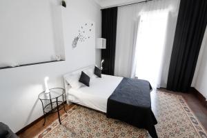 a bedroom with a white bed and a window at Pegaso in Catania